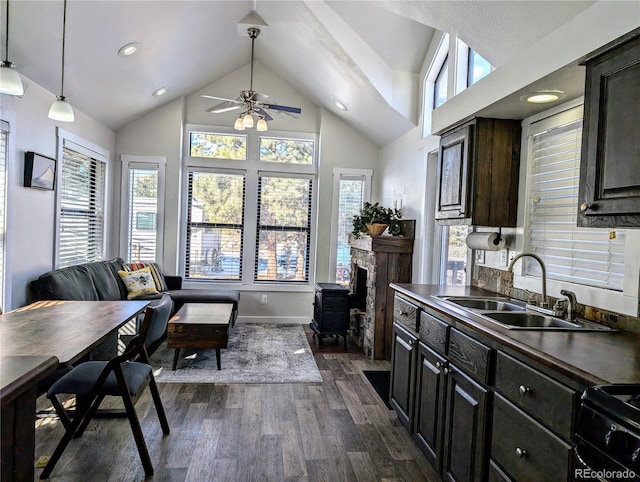 kitchen featuring sink, dark hardwood / wood-style floors, black / electric stove, pendant lighting, and vaulted ceiling