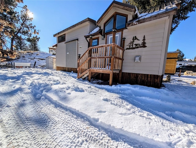 view of snow covered back of property