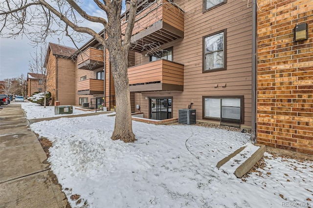 snow covered property featuring central AC