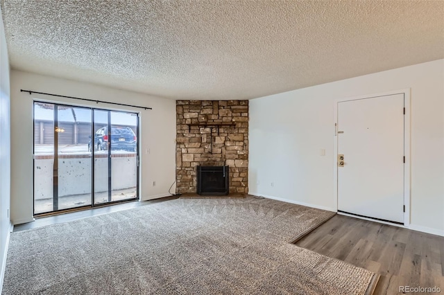 unfurnished living room with a fireplace, a textured ceiling, and hardwood / wood-style flooring