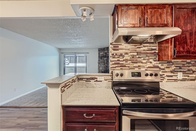 kitchen featuring backsplash, stainless steel range with electric cooktop, exhaust hood, light hardwood / wood-style flooring, and kitchen peninsula