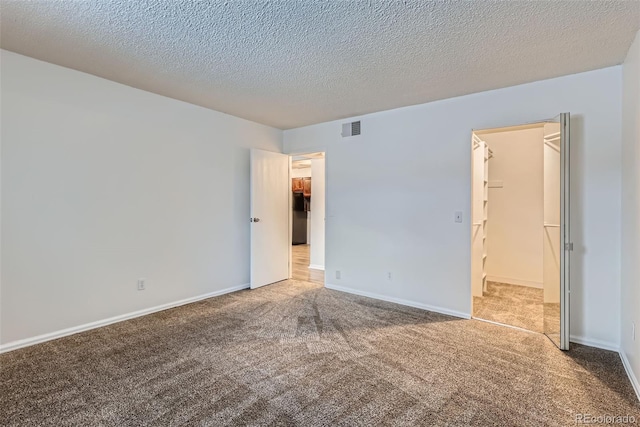 empty room featuring carpet and a textured ceiling