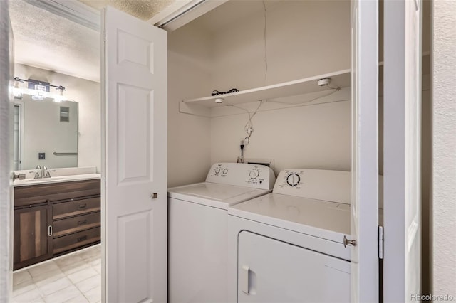 washroom with independent washer and dryer, a textured ceiling, and sink