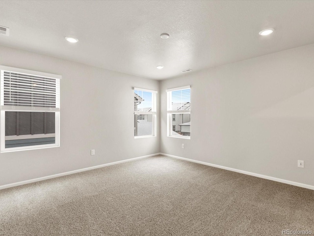 carpeted spare room featuring a textured ceiling