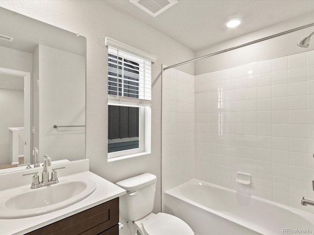 full bathroom featuring tiled shower / bath combo, vanity, and toilet