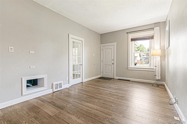 spare room with a textured ceiling and hardwood / wood-style floors