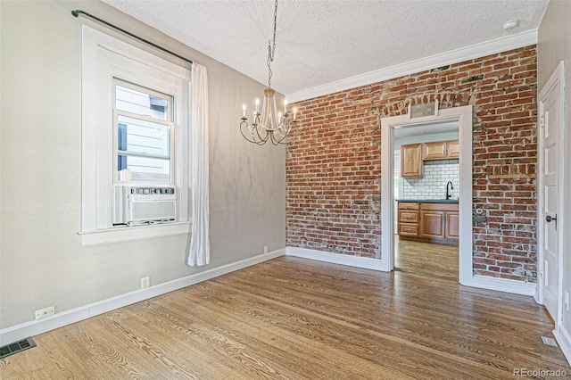 unfurnished dining area featuring a textured ceiling, brick wall, and dark hardwood / wood-style floors