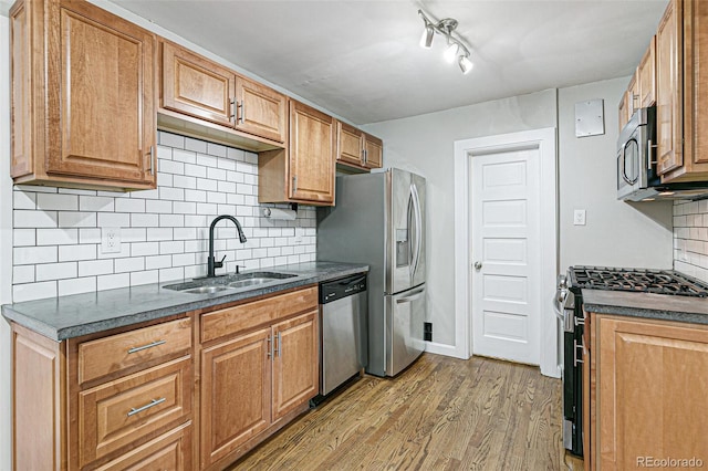 kitchen featuring decorative backsplash, sink, stainless steel appliances, and light hardwood / wood-style floors