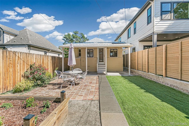 back of property featuring a patio area and a lawn