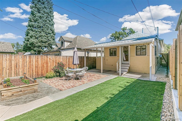 rear view of house with a yard and a patio