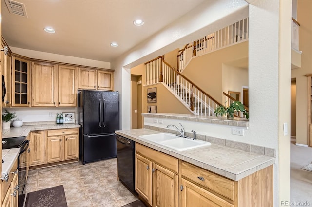 kitchen featuring kitchen peninsula, tile counters, black appliances, and sink