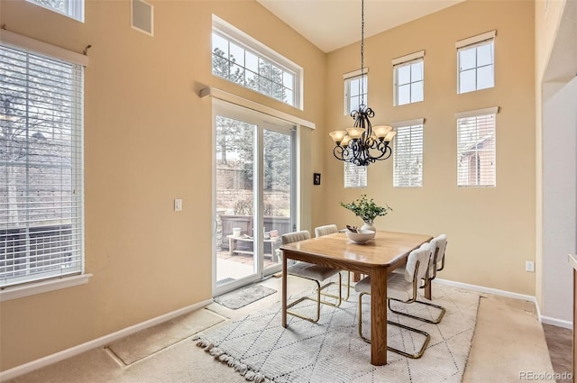 dining room with light colored carpet and a notable chandelier