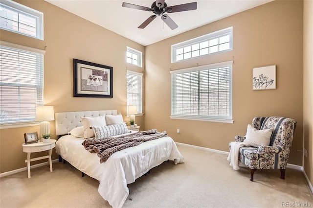 carpeted bedroom featuring multiple windows and ceiling fan