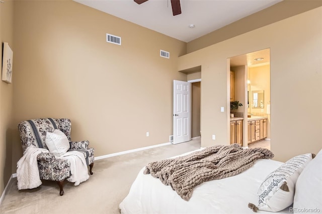 carpeted bedroom with ensuite bathroom and ceiling fan