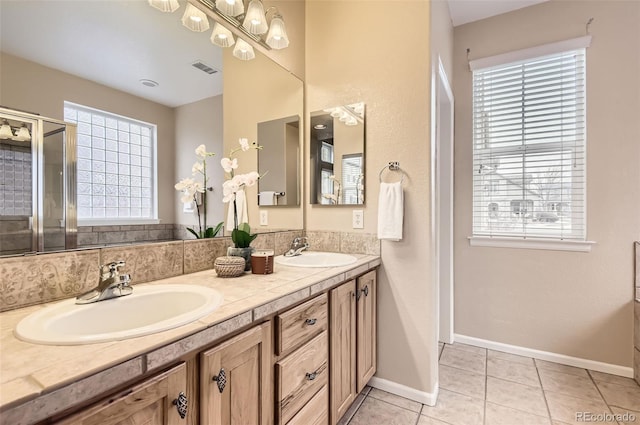 bathroom with tile patterned flooring, vanity, and a healthy amount of sunlight