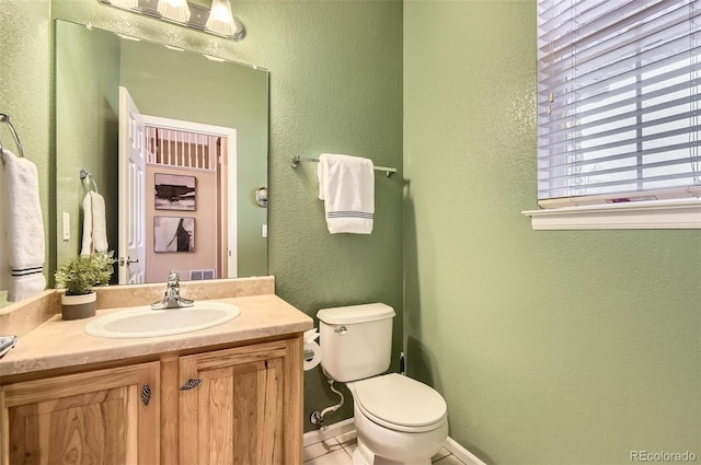 bathroom featuring tile patterned flooring, vanity, and toilet