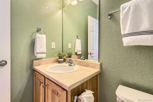 bathroom featuring vanity and toilet