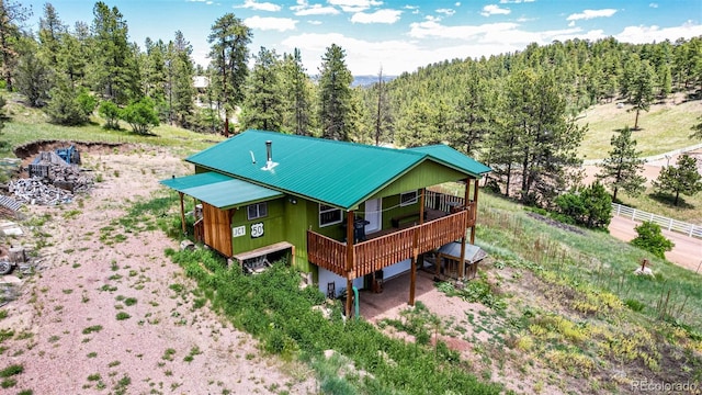 435 Sourwood Ln, Canon City, CO 81212 - rear view of house with a metal roof, a deck, and a forest view