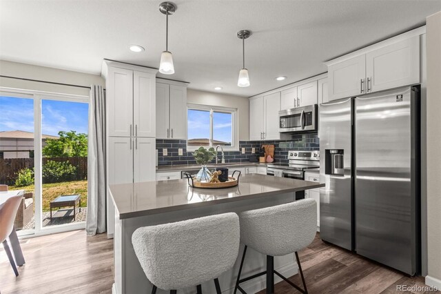 13542 Achilles Dr, Lone Tree, CO 80124 - kitchen featuring appliances with stainless steel finishes, tasteful backsplash, white cabinets, hanging light fixtures, and recessed lighting