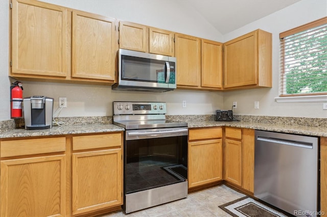 6534 S Union Way, Littleton, CO 80127 - kitchen with appliances with stainless steel finishes, light brown cabinetry, lofted ceiling, light stone countertops, and light tile patterned floors