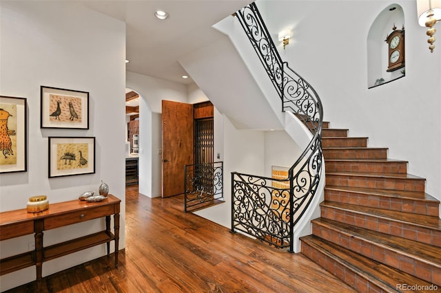 458 Adams St, Denver, CO 80206 - staircase featuring arched walkways, wood finished floors, and recessed lighting