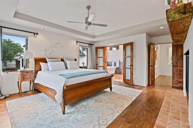 458 Adams St, Denver, CO 80206 - bedroom featuring recessed lighting, wood finished floors, a tray ceiling, ceiling fan, and connected bathroom