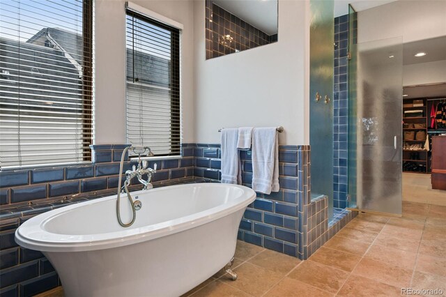 458 Adams St, Denver, CO 80206 - full bath featuring a freestanding bath, a shower stall, healthy amount of natural light, and tile walls