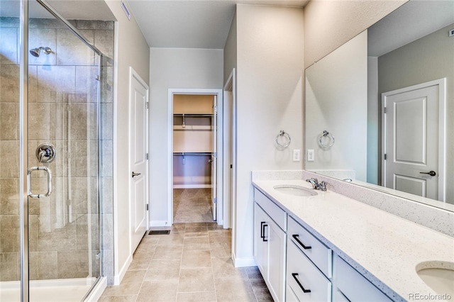 bathroom with vanity, a shower with door, and tile patterned floors