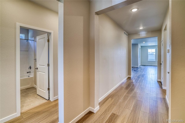 corridor with light hardwood / wood-style floors