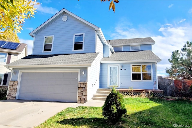 view of property with a front yard and a garage