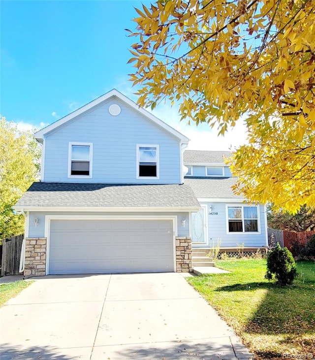 view of property with a garage and a front lawn