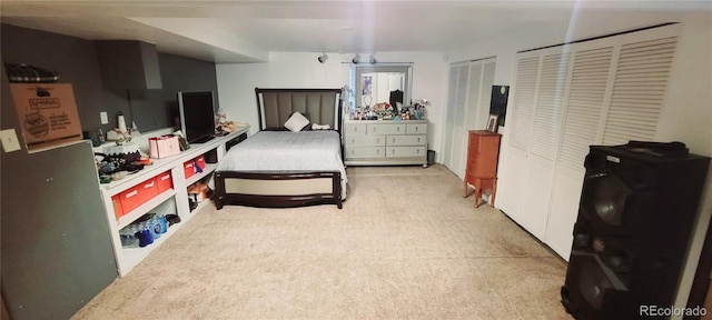 bedroom featuring two closets and light colored carpet