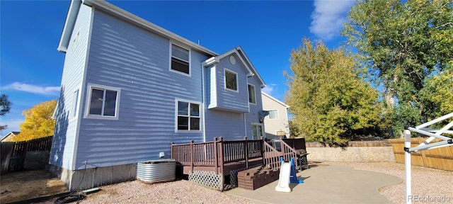 back of house featuring central air condition unit, a patio area, and a wooden deck