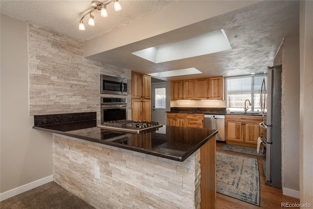 kitchen featuring stainless steel appliances, sink, a wealth of natural light, and kitchen peninsula