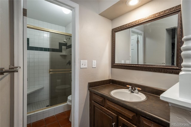 bathroom with vanity, tile patterned flooring, toilet, and walk in shower