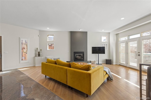 living room with light wood-type flooring and a large fireplace