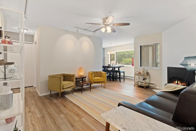 534 E 7th Ave Unit 101, Denver, CO 80203 - living room with rail lighting, light wood-type flooring, ceiling fan, a baseboard heating unit, and a textured ceiling