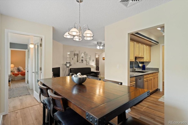 534 E 7th Ave Unit 101, Denver, CO 80203 - dining space featuring light wood-style flooring, a chandelier, ceiling fan, and a textured ceiling