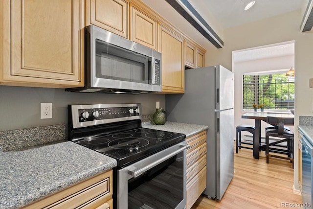 534 E 7th Ave Unit 101, Denver, CO 80203 - kitchen featuring appliances with stainless steel finishes, light wood-style floors, and light brown cabinetry