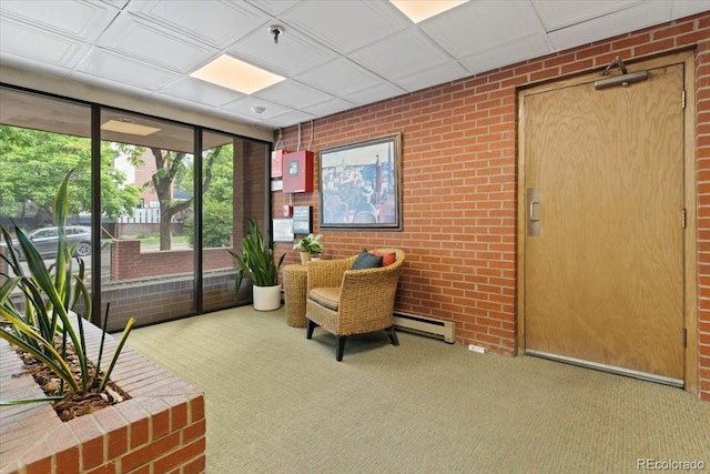 534 E 7th Ave Unit 101, Denver, CO 80203 - sitting room with a baseboard radiator, carpet, brick wall, and expansive windows