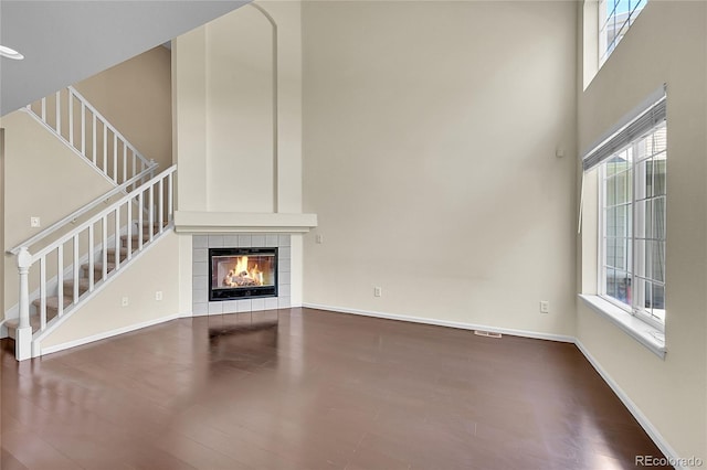 4006 E Geddes Cir, Centennial, CO 80122 - unfurnished living room featuring stairs, wood finished floors, a fireplace, and a high ceiling