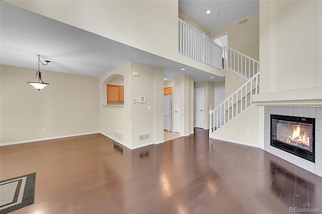 4006 E Geddes Cir, Centennial, CO 80122 - unfurnished living room with wood finished floors, a tile fireplace, stairway, and a high ceiling