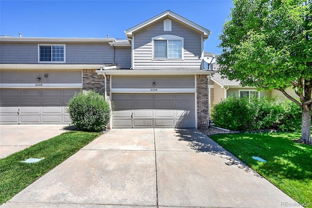 4006 E Geddes Cir, Centennial, CO 80122 - view of front facade featuring concrete driveway, brick siding, a front yard, and an attached garage