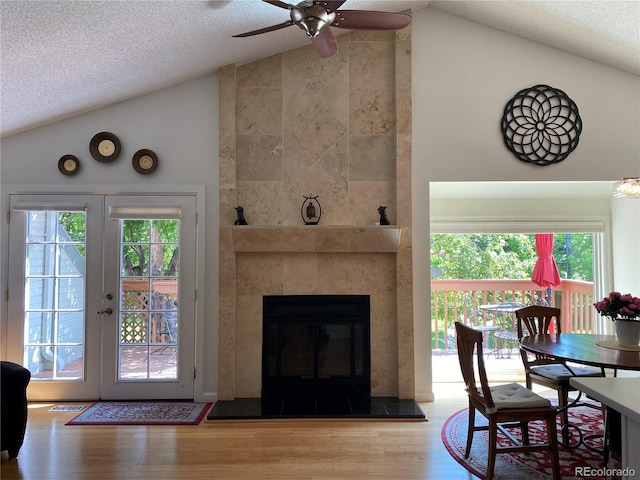 5479 E Weaver Ave, Centennial, CO 80121 - dining room with lofted ceiling, wood finished floors, a ceiling fan, a textured ceiling, and a tiled fireplace
