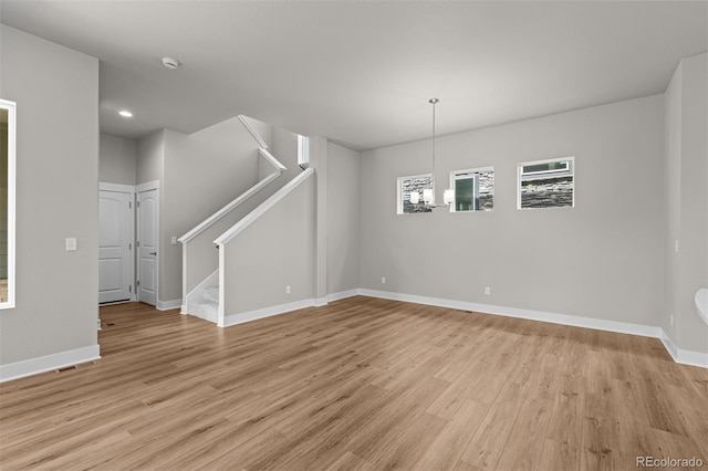 21034 E 63rd Dr, Aurora, CO 80019 - unfurnished living room featuring light wood-style flooring, stairway, and recessed lighting