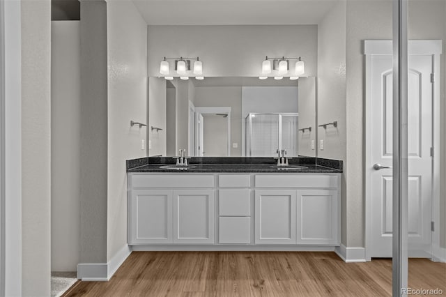 21034 E 63rd Dr, Aurora, CO 80019 - full bath featuring wood finished floors, double vanity, a shower stall, and a textured wall