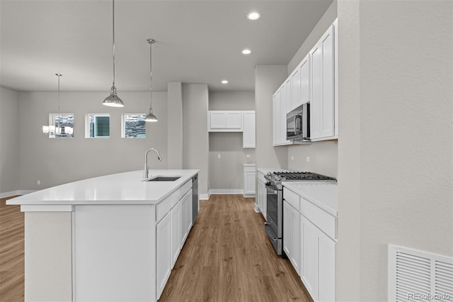 21034 E 63rd Dr, Aurora, CO 80019 - kitchen with stainless steel appliances, light wood finished floors, white cabinets, light countertops, and recessed lighting