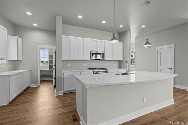 21034 E 63rd Dr, Aurora, CO 80019 - kitchen with stainless steel appliances, recessed lighting, wood finished floors, white cabinetry, and light countertops