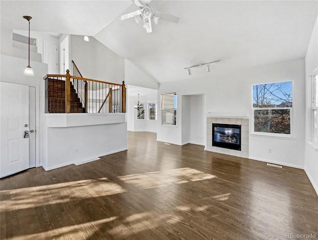 unfurnished living room with dark hardwood / wood-style flooring, vaulted ceiling, and a healthy amount of sunlight