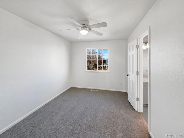 carpeted spare room featuring ceiling fan